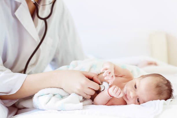 pediatrician doctor examines newborn with stethoscope